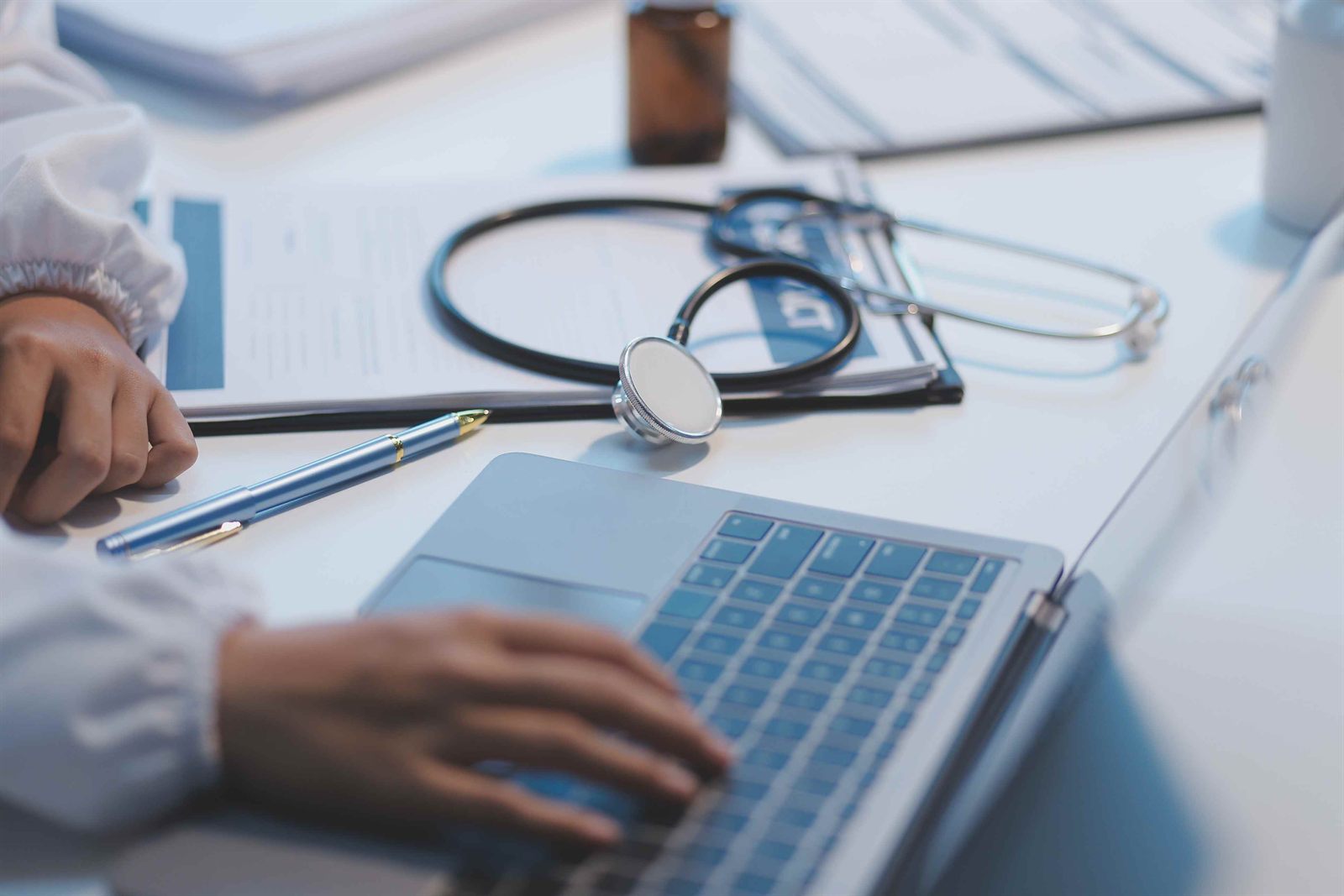 Mental health provider using laptop with stethoscope on desk