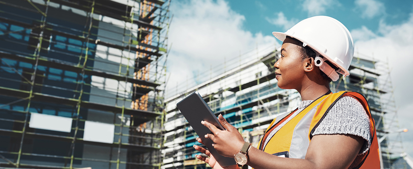 Construction worker leveraging IT support for construction.  