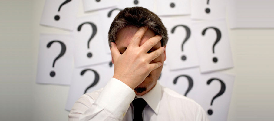 Man facepalming surrounded by question marks
