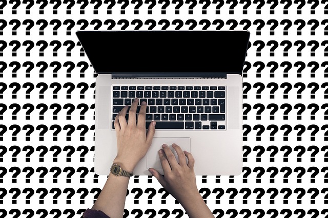 laptop surrounded by question marks