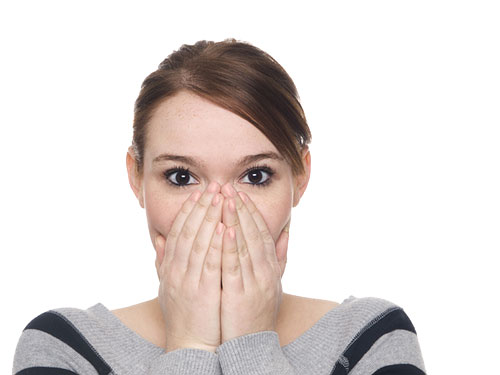 Woman holding hands over mouth in surprise